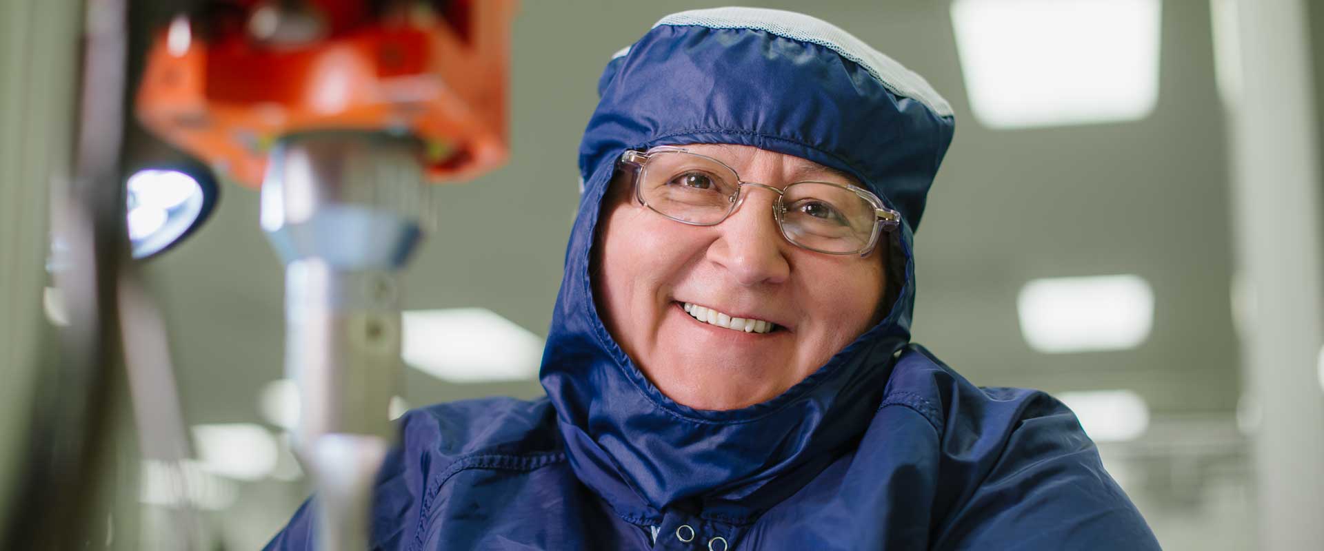 Headshot of a woman smiling while wearing protective gear. 