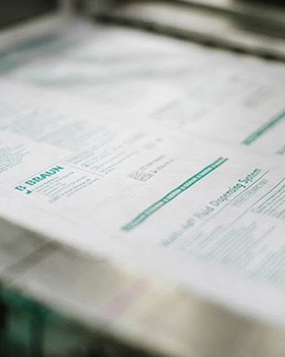 A close-up of a piece of paper with printed text and graphics, primarily in shades of green and white. The top left corner features the ‘B. Braun’ logo.