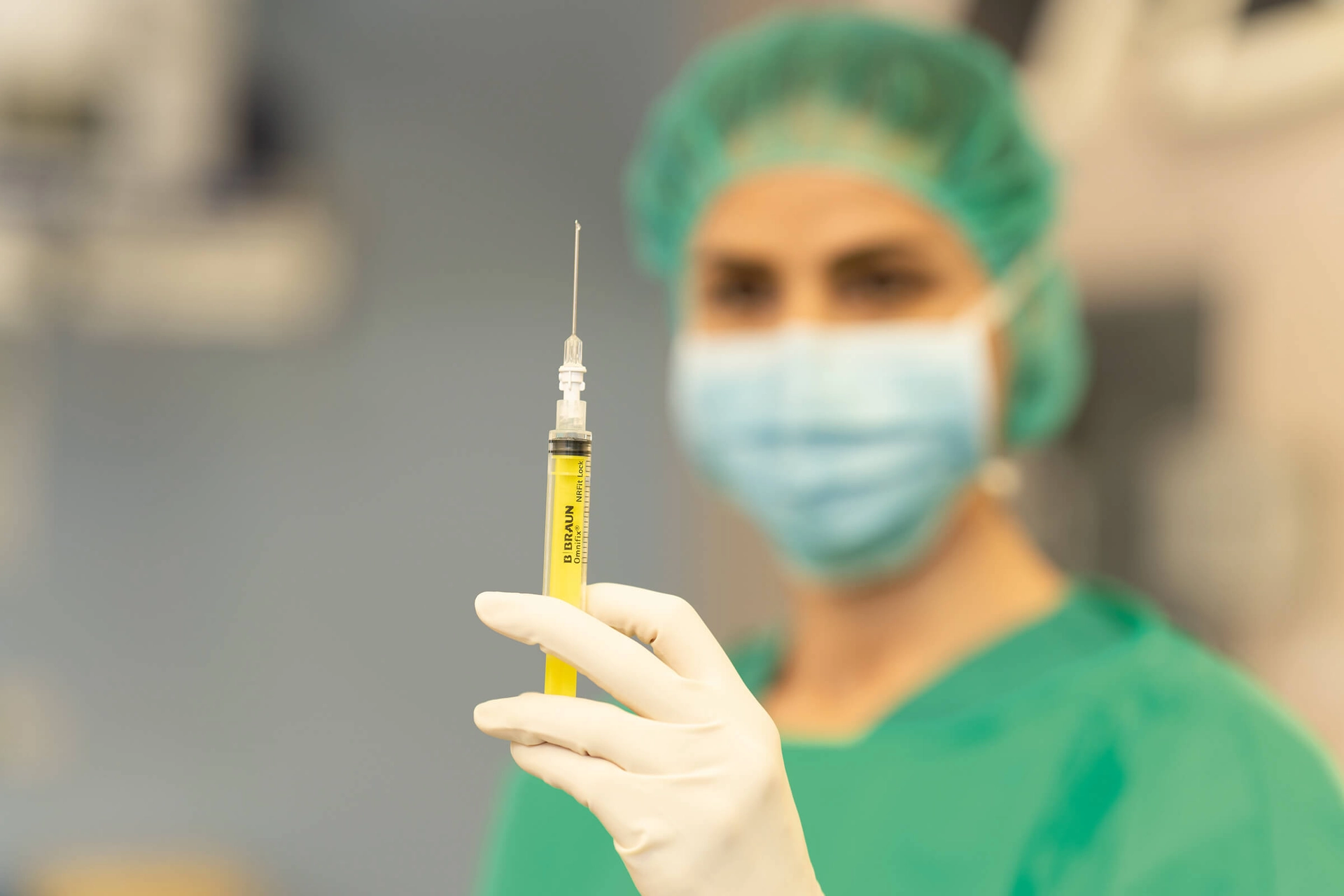 blurry-nurse-holding-nrfit-syringe