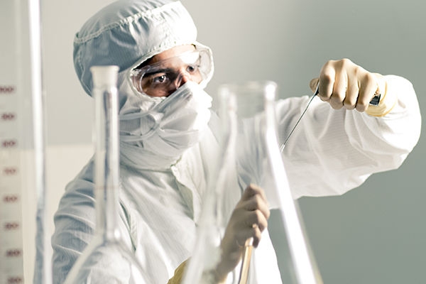 Person with safety gear on sterilizing in a laboratory. 