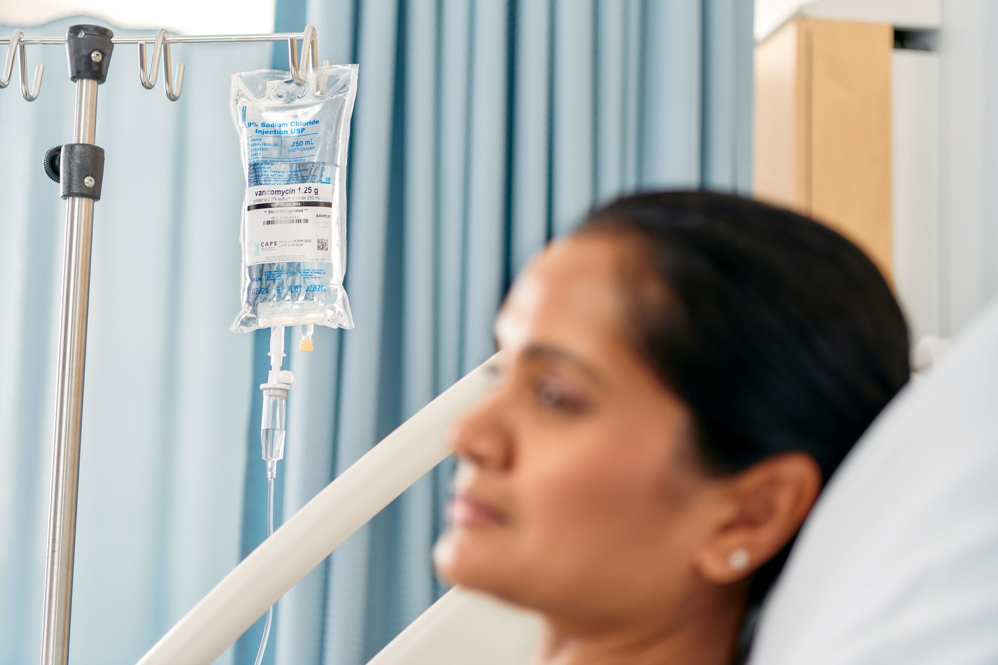blurred-patient-lying-in-bed-focused-in-on-a-container