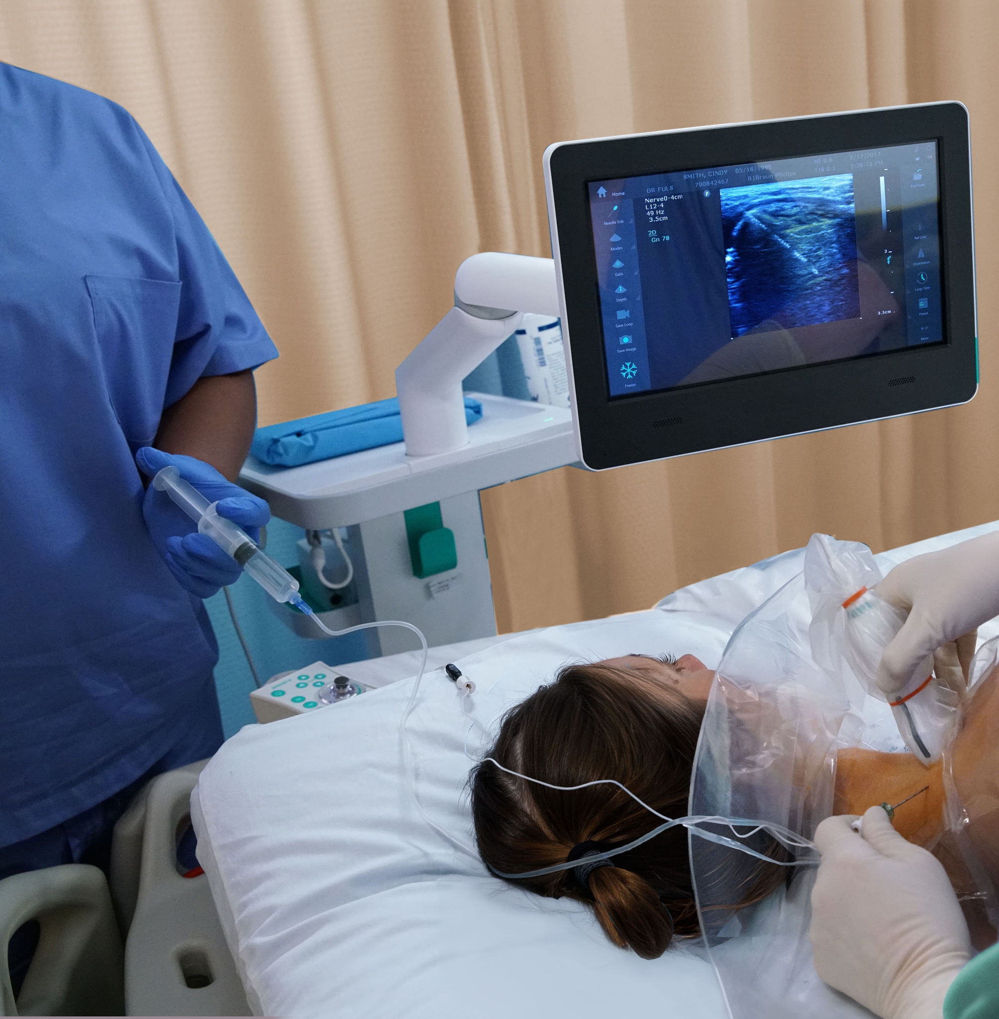 Ultrasound-guided regional anesthesia procedure being performed at a patient's bedside.