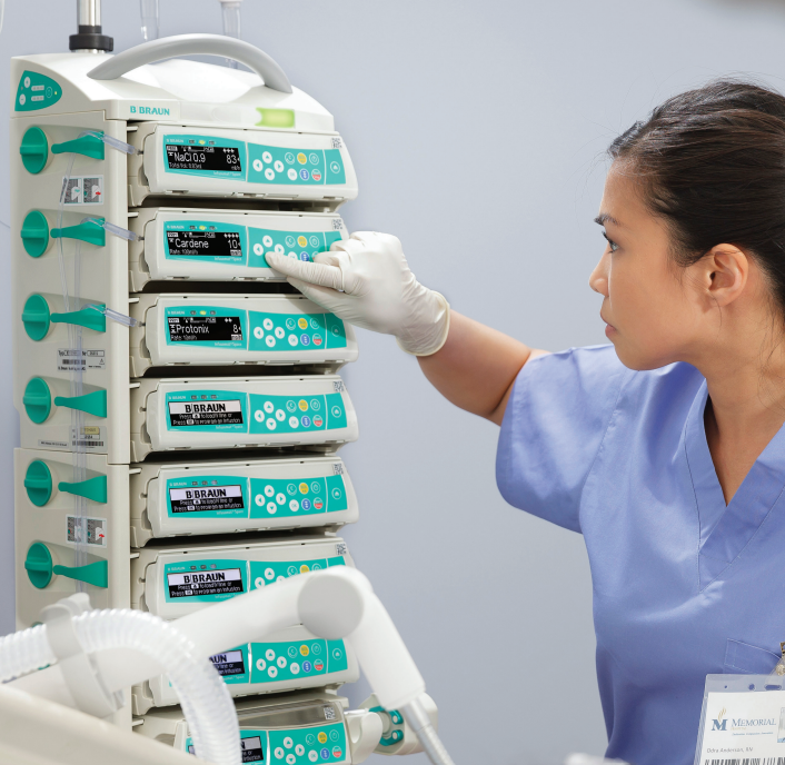 A close-up of a nurse standing as she programs a B. Braun SpaceStation.