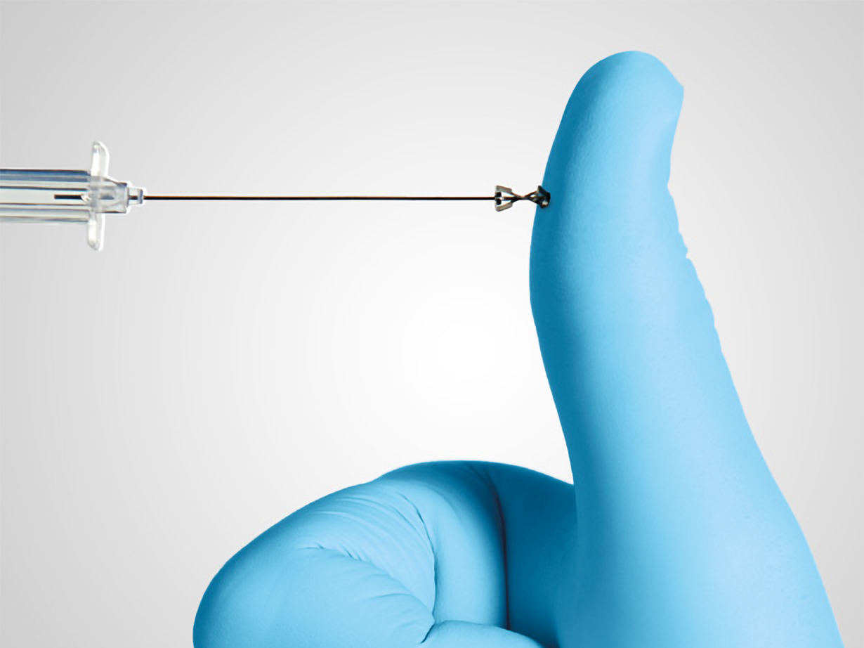 Introcan Safety IV Catheter showcasing passive safety technology as the device presses against a blue-gloved thumb. 